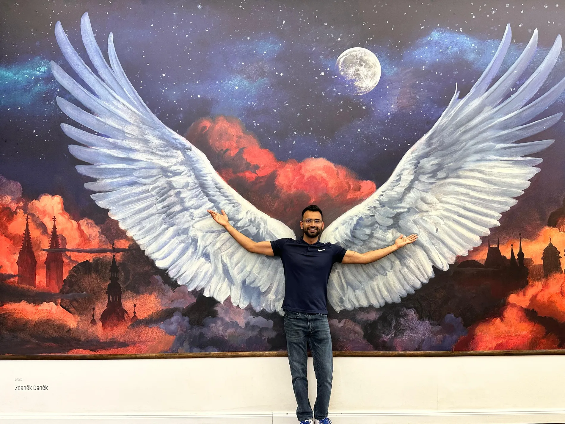 Ayush in front of a winged mural